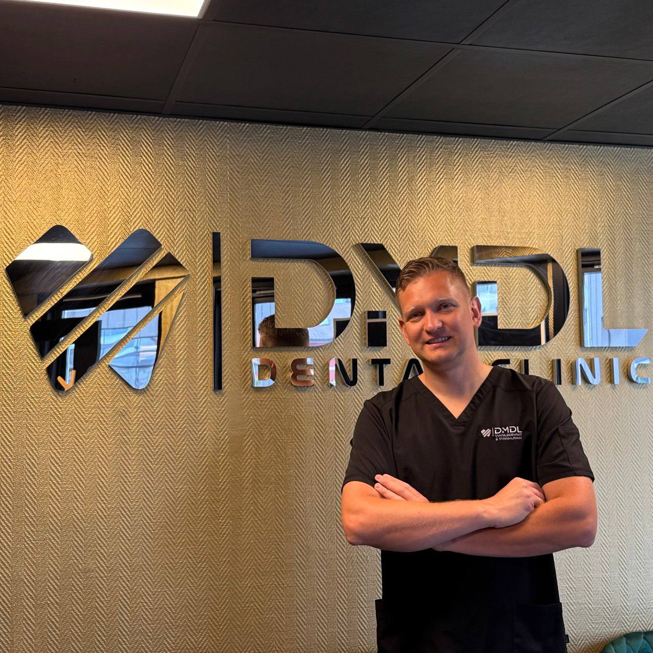 Tannlege Dmitrij Chaustovic legger en tannfarget fylling hos DMDL Tannklinikk i Kristiansand.